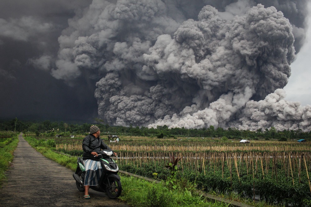 A man looks at a pyroclastic flow during the eruption of Mount Semeru on 19 November 2025 (AFP/Getty)