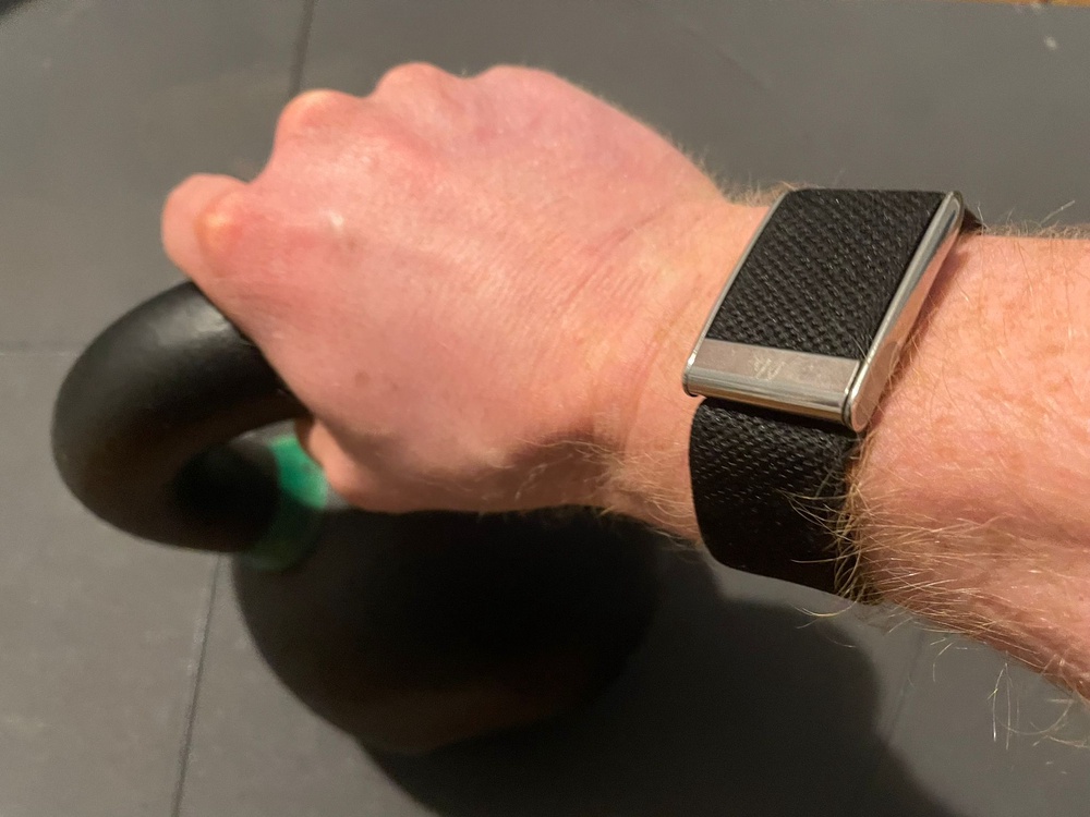 The Whoop 5.0 is significantly chunkier than the Fitbit Air (Harry Bullmore/The Independent)