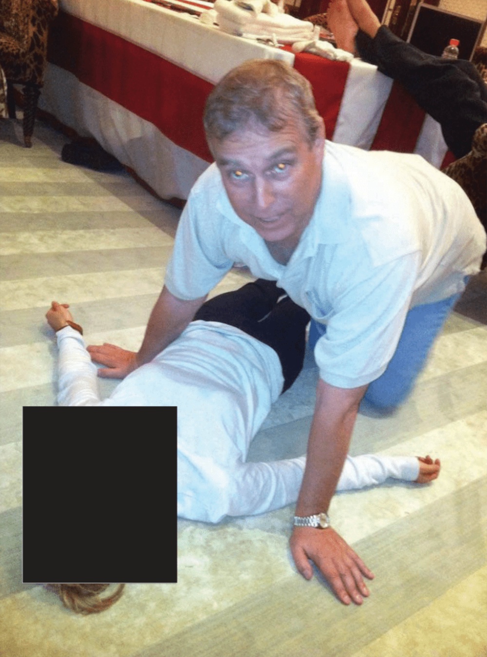 A photograph appearing to show Andrew Mountbatten-Windsor crouched over an unidentified woman which has been released in the latest disclosure of files linked to Jeffrey Epstein (US Department of Justice)