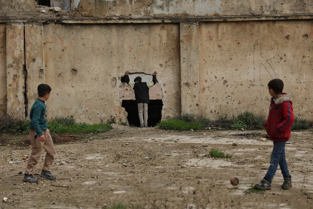 Children play near a war-damaged school in Aleppo, Syria (AP)