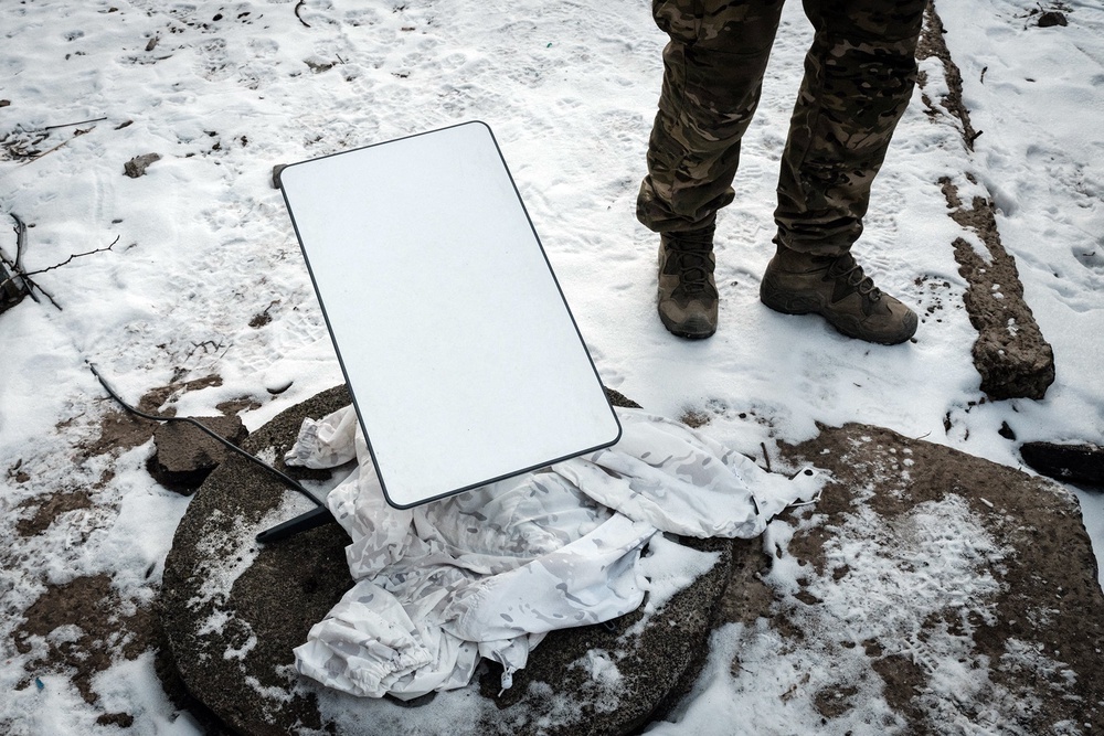 A Ukrainian serviceman stands next to the antenna of the Starlink satellite-based broadband system in Bakhmut (AFP/Getty)
