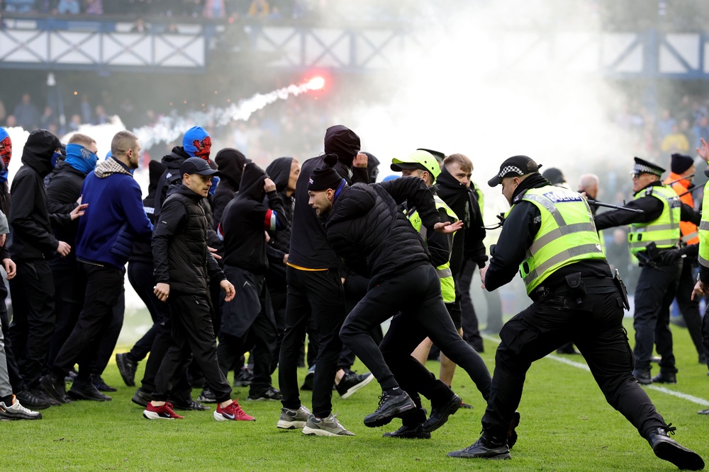 Police and stewards force fans back after they invaded the Ibrox pitch (PA Wire)