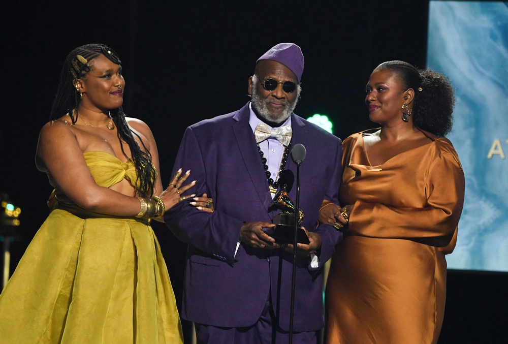 Taj Mahal accepting the Grammy for Best Traditional Blues Album for ‘Swingin’ Live at The Church in Tulsa’ in 2025, flanked by his daughters Zoe Moon and Deva Mahal (AFP/Getty)