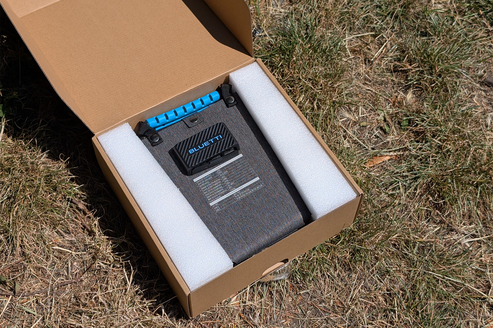 Unpacking the Bluetti in some seriously sun-scorched grass (Steve Hogarty/The Independent)