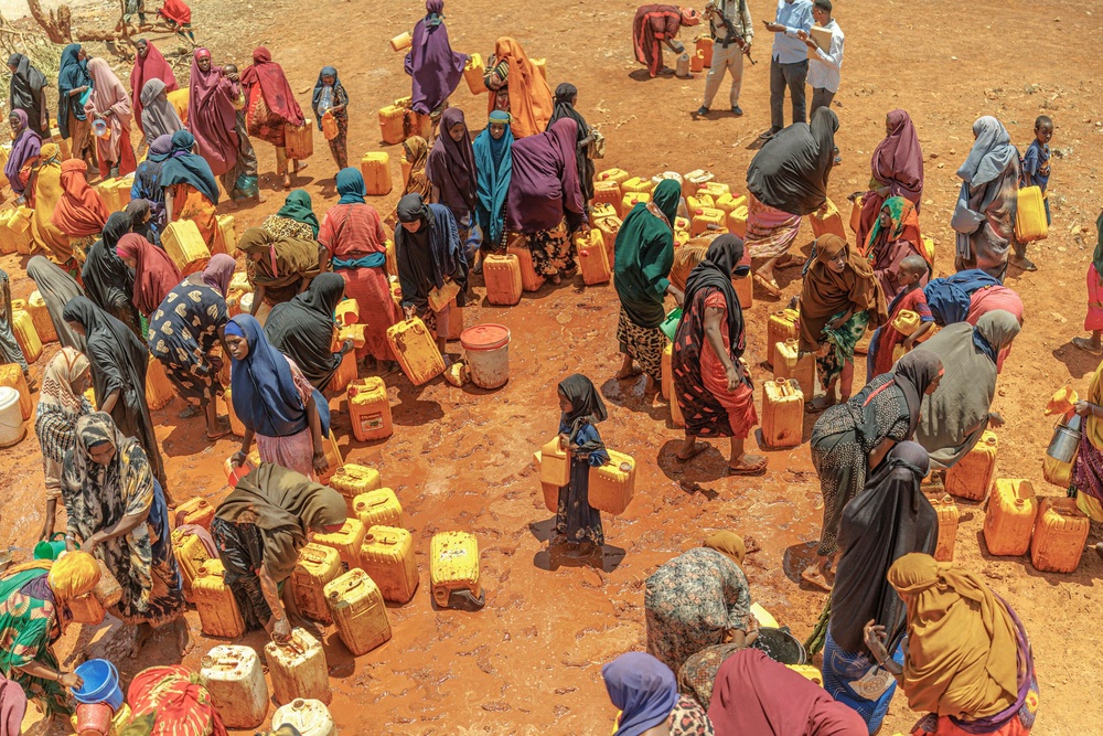 People displaced by drought in Somalia flock around a water delivery in the camp where they live (Mercy Corps)