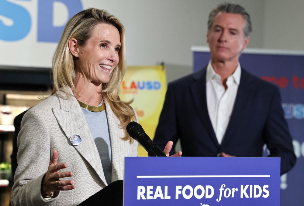 Newsom looks on as his wife, Jennifer Siebel Newsom, speaks at Belvedere Middle School before he signed legislation aimed at improving kids' nutrition (Getty Images)