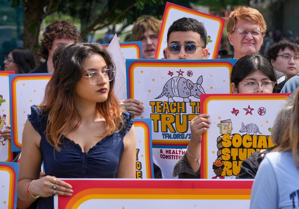 People hold signs reading 