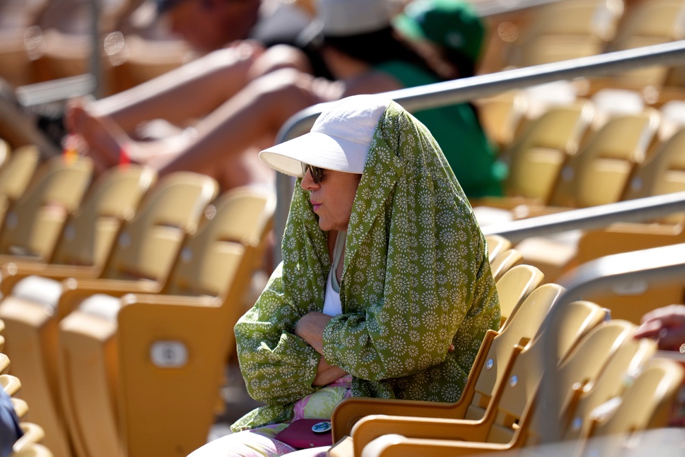 A baseball fan tries to shield from the sun during the fourth inning of a spring training baseball game between the Chicago White Sox and the Athletics. (Copyright 2026 The Associated Press. All rights reserved)