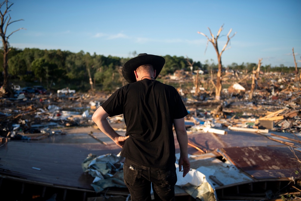 Tony McFall wears his father's cowboy hat, while looking over the debris of his father's and stepmother's house, who lost their lives during a tornado in Sunshine Hills, Kentucky, last May. Experts say people who hear tornado warnings should immediately seek shelter (Getty Images)
