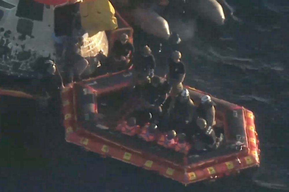 The Artemis II astronauts huddle on the inflatable 'front porch' after safely exiting the Integrity crew capsule. (NASA via YouTube)