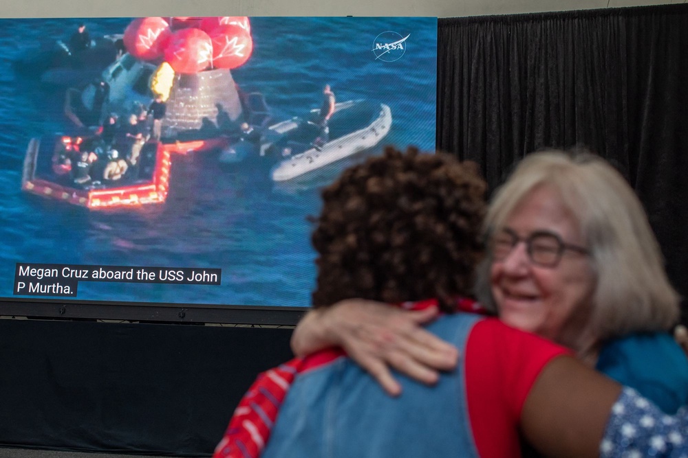 People hug as they watch a live broadcast of the return of the Artemis II crew members to Earth at the San Diego Air and Space Museum during a watch party for the crew's splash down in the Pacific Ocean, in San Diego, California, on April 10, 2026. (Apu GOMES / AFP via Getty Images)