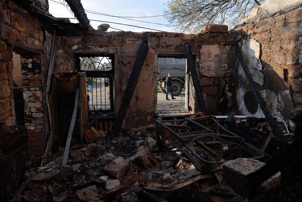 A local resident walks past a destroyed house following an air attack in Odesa on Saturday (AFP via Getty Images)