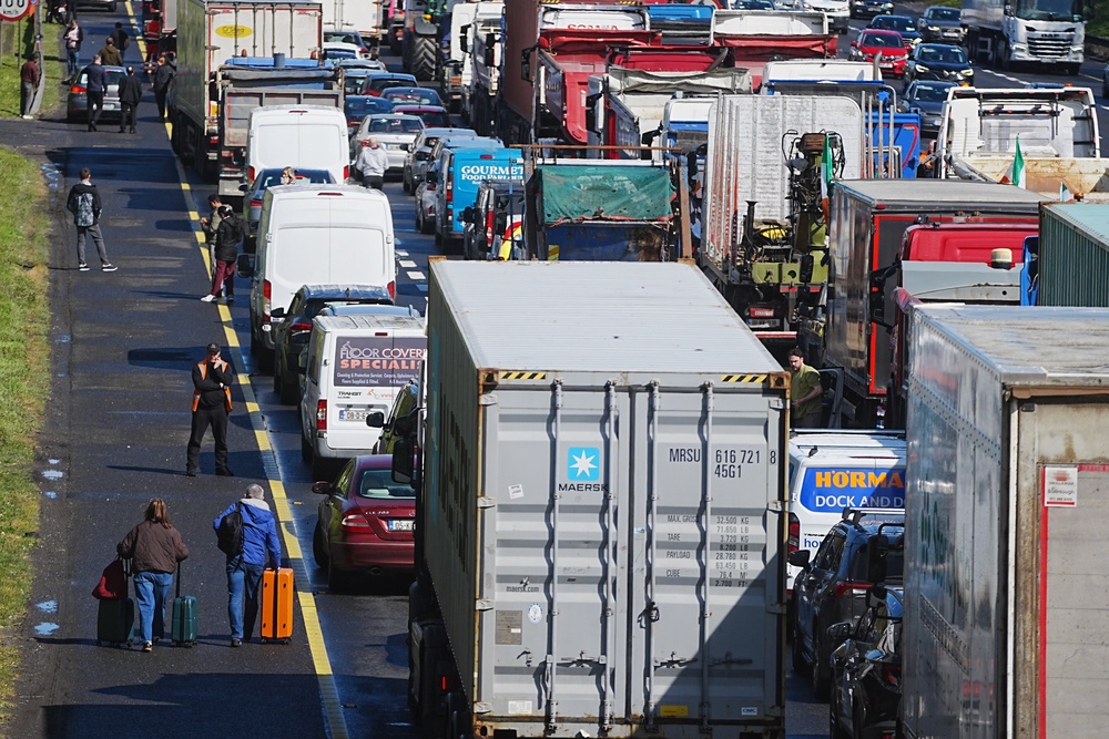 People with their luggage walk past the heavy traffic on Dublin’s M50 (Brian Lawless/PA) (PA Wire)