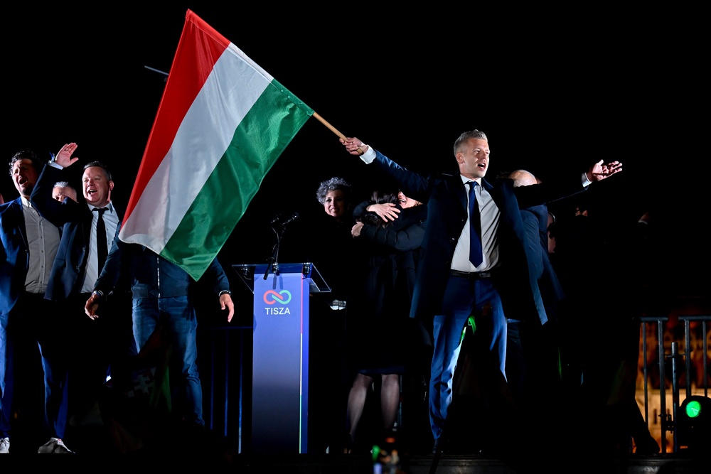 Peter Magyar, leader of the opposition Tisza party, waves the Hungarian flag following the announcement of the partial results of the parliamentary election, in Budapest. (Copyright 2026 The Associated Press. All rights reserved.)