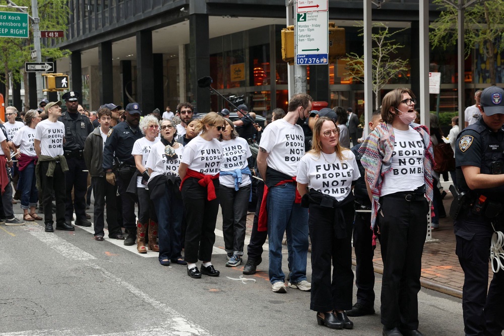 Demonstrators wear t-shirts reading 'Fund people not bombs' (REUTERS)