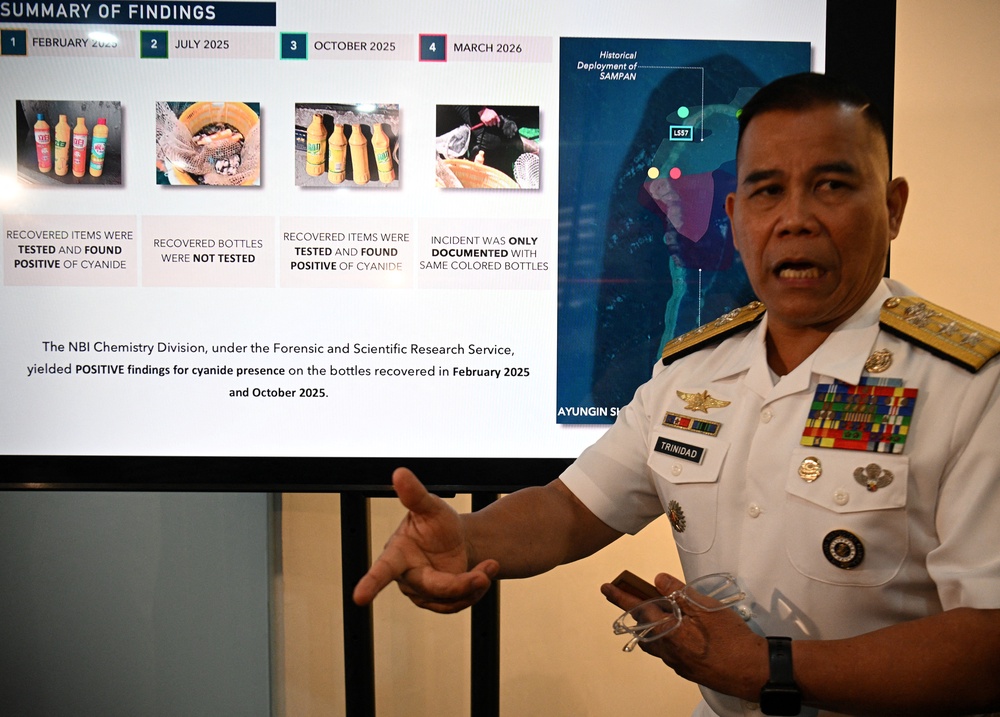Philippine Navy spokesman Rear Admiral Roy Vincent Trinidad speaks next to a slide presentation of seized yellow bottles suspected to contain cyanide in waters of Second Thomas Shoal in the disputed South China Sea, during a press conference in Manila (AFP/Getty)
