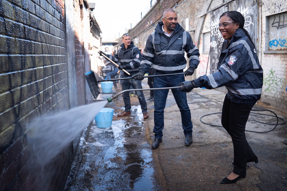 Conservative Party leader Kemi Badenoch joined by then shadow housing secretary James Cleverly help to clean graffiti off a wall in Herne Hill, south London, while on the party’s campaign trail for May’s local elections (PA)