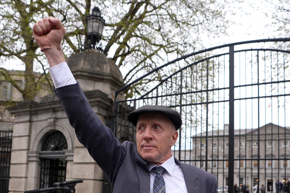 Independent TD Michael Healy-Rae raising his fist to the crowds gathered outside Leinster House (Niall Carson/PA) (PA Wire)