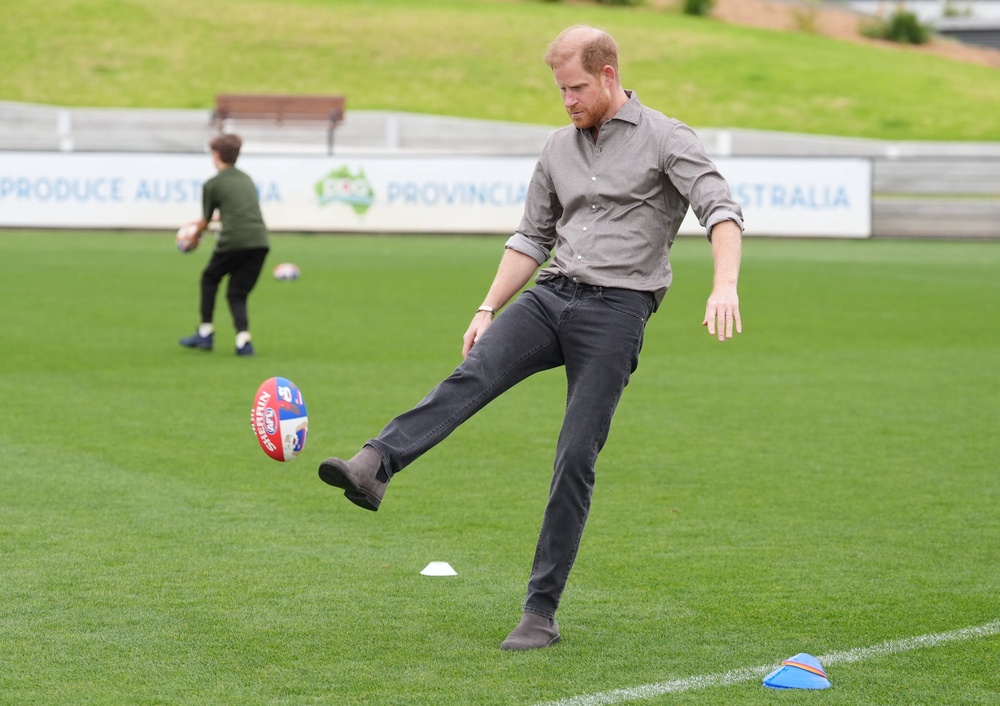 Harry kicked an Australian rules football as he met with Western Bulldogs players (Jonathan Brady/PA) (PA Wire)
