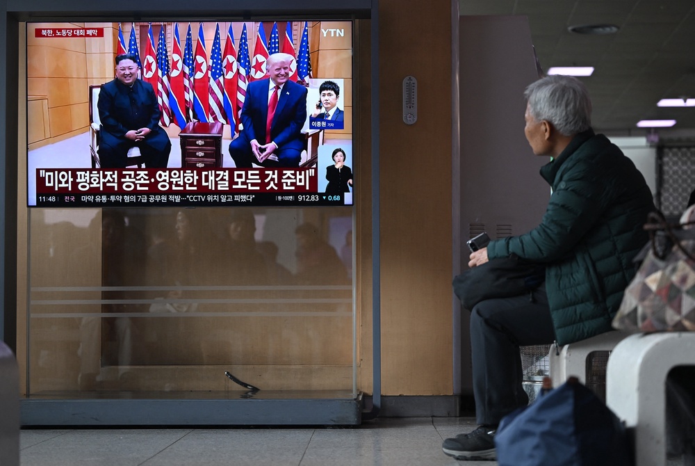 A man watches a news broadcast in Seoul showing a file photo of North Korean leader Kim Jong Un meeting with US president Donald Trump (AFP via Getty)