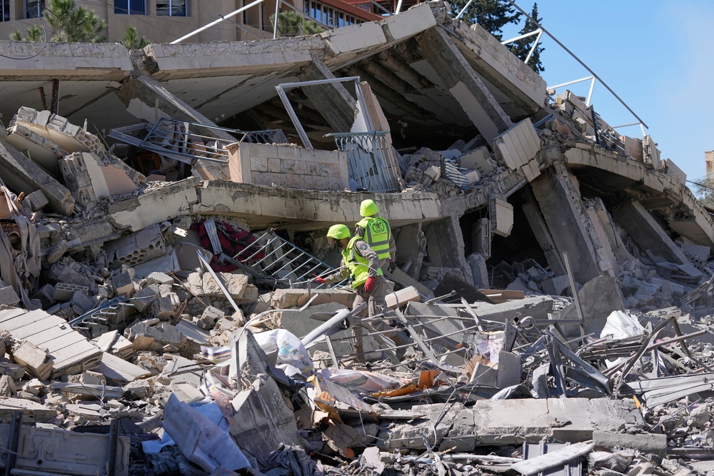 Rescue workers check a destroyed building hit by an Israeli airstrike in Nabatiyeh town, south Lebanon, last month (PA)