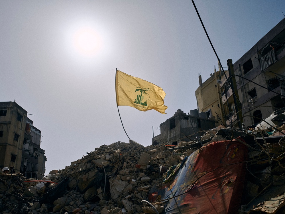 A Hezbollah flag flies over the ruins of an Israeli airstrike in the southern Beirut suburb of Dahiye al-Salam on 13 April (AFP/Getty)