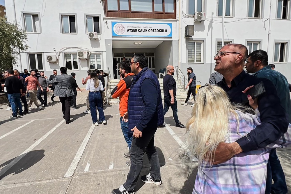 People stand in the courtyard of a secondary school where a gunman opened fire in Kahramanmaras, Turkey, on Wednesday (IHA)
