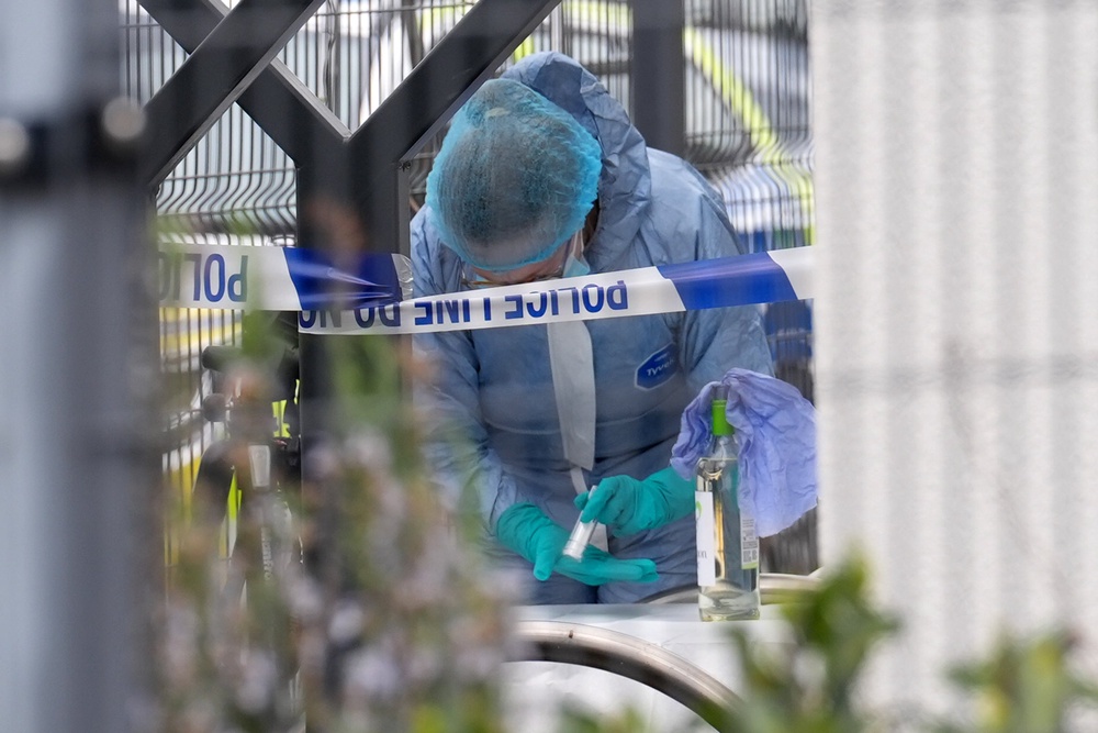 A police forensic officer looking at a wine bottle outside Finchley Reform Synagogue in north London (Lucy North/PA) (PA Wire)
