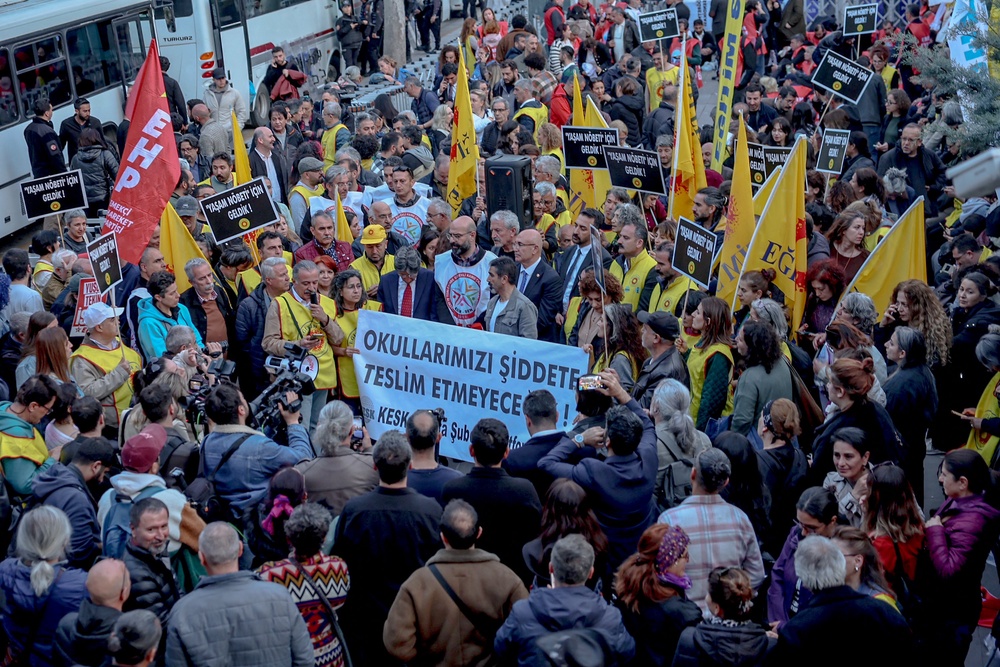 Members of education unions chant slogans as they hold a banner which reads