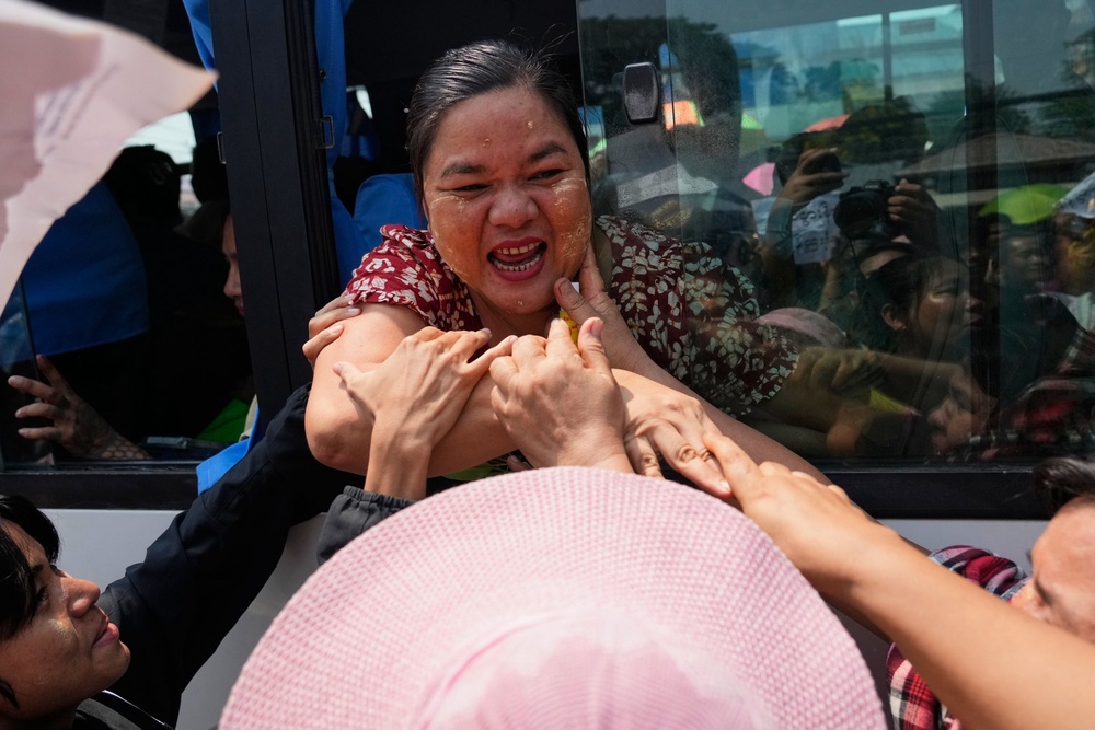Released prisoners, in a bus, are welcomed by family members and colleagues after they left Insein Prison in Yangon (AP)