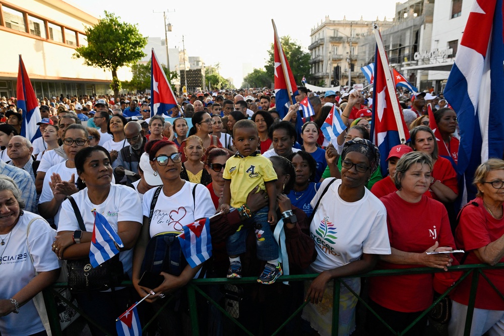 People take part in a ceremony marking the 65th anniversary of Fidel Castro's declaration of the socialist character of the Cuban Revolution, on 16 April (Reuters)
