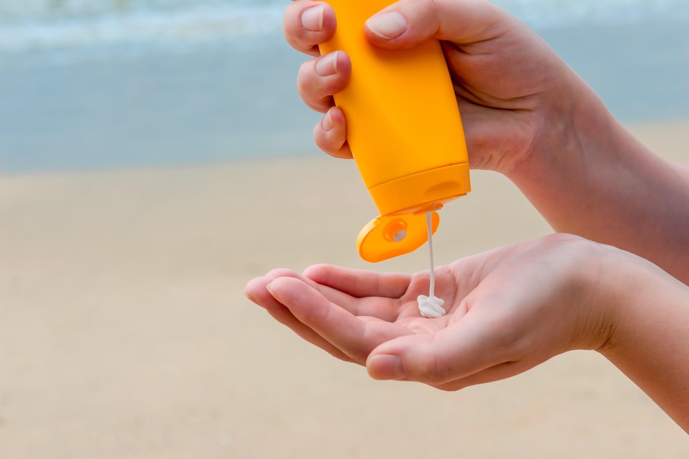 Close-up of woman squirting suncream into her hand (Alamy/PA)