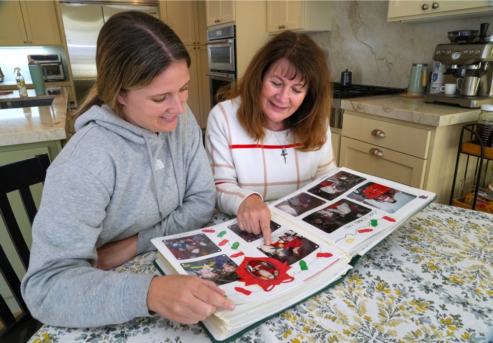 Kelley Nalewaja, right, looks over photos of her son, Michael Nalewaja, who died after unknowingly taking a lethal cocktail of fentanyl and carfentanil in November 2025, with her daughter, Caroline Bendel (AP)
