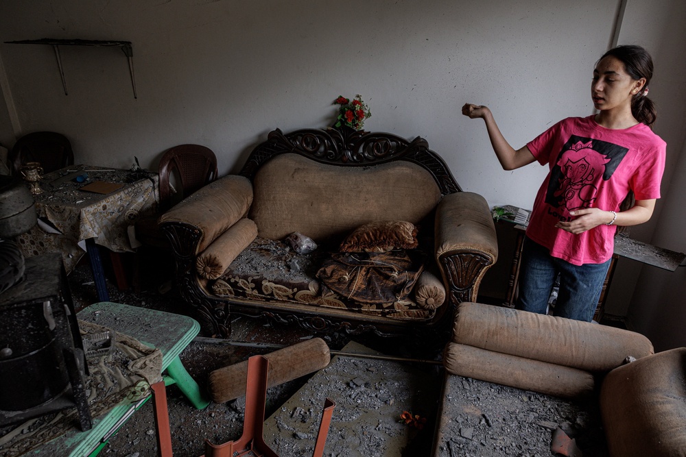 Haya Dahnoun, 14, who said she survived an Israeli strike that forced her to flee with her parents from Nabatieh to Beirut, recounts the day they were hit as she stands in her neighbour's damaged sitting room after returning home, on 18 April (Reuters)
