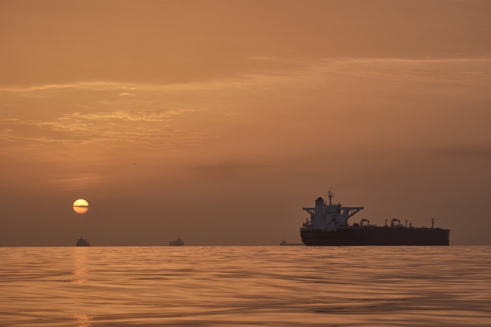 The sun rises behind tankers anchored in the Strait of Hormuz off the coast of Qeshm Island, Iran, Saturday, April 18 (AP)