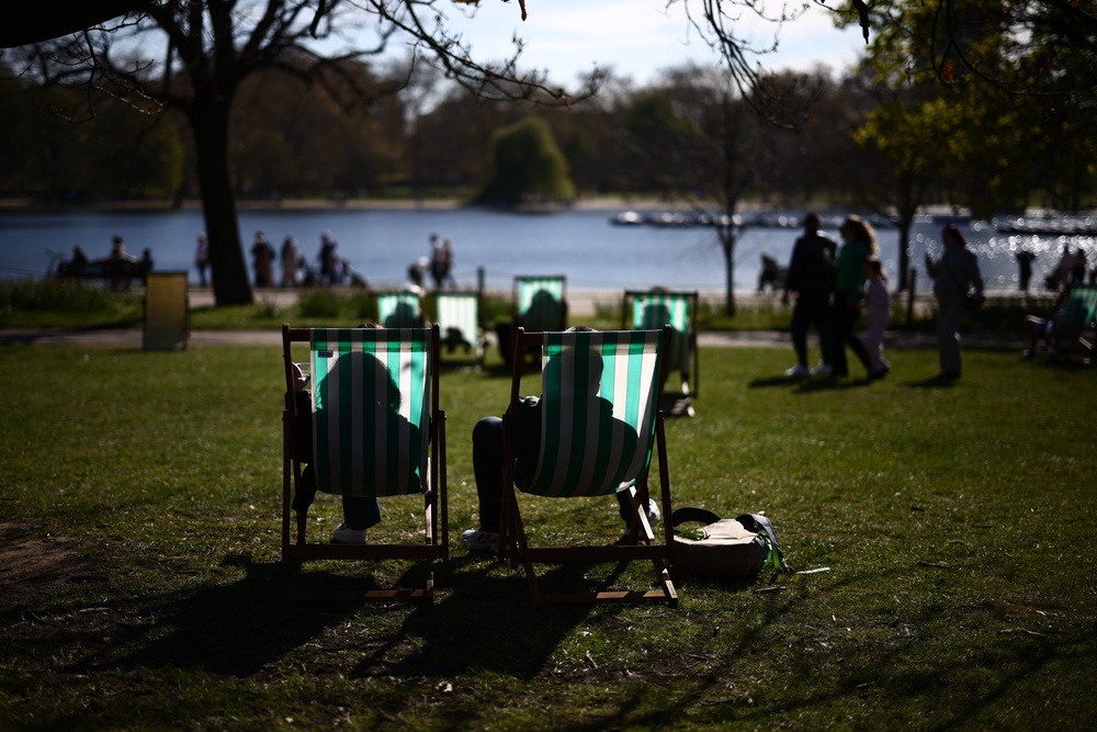 People sit on sun loungers on the banks of The Serpentine lake in Hyde Park, London (AFP/Getty)