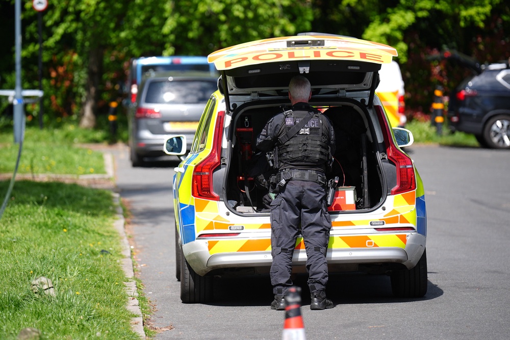 A police firearms officer outside the Kenton United Synagogue in Harrow, north-west London, where an attempted arson attack overnight has caused minor smoke damage to an internal room but no injuries or significant structural damage (PA)