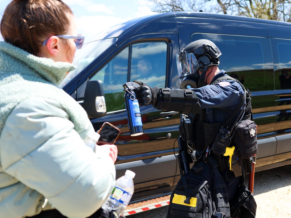 A Wisconsin State Patrol officer points a can of mace at activists as officers make way for a van to leave the grounds of Ridglan Farms beagle breeding and research facility (AP)