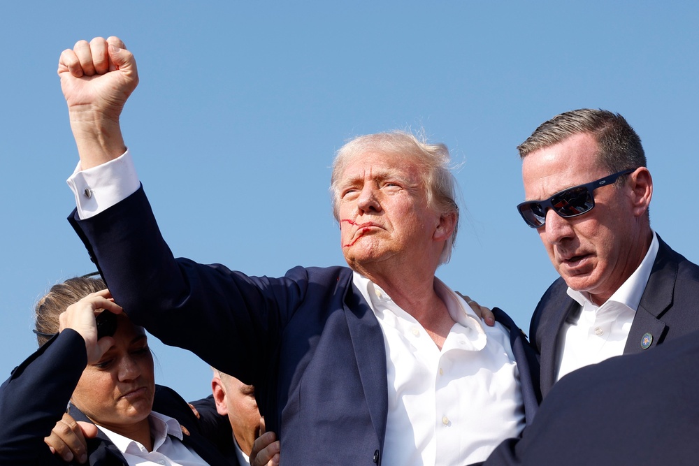 The image of Trump raising his fist after surviving an assassination attempt in Pennsylvania has become one of the most well-known photos of the president, often used to display his strength (Getty)