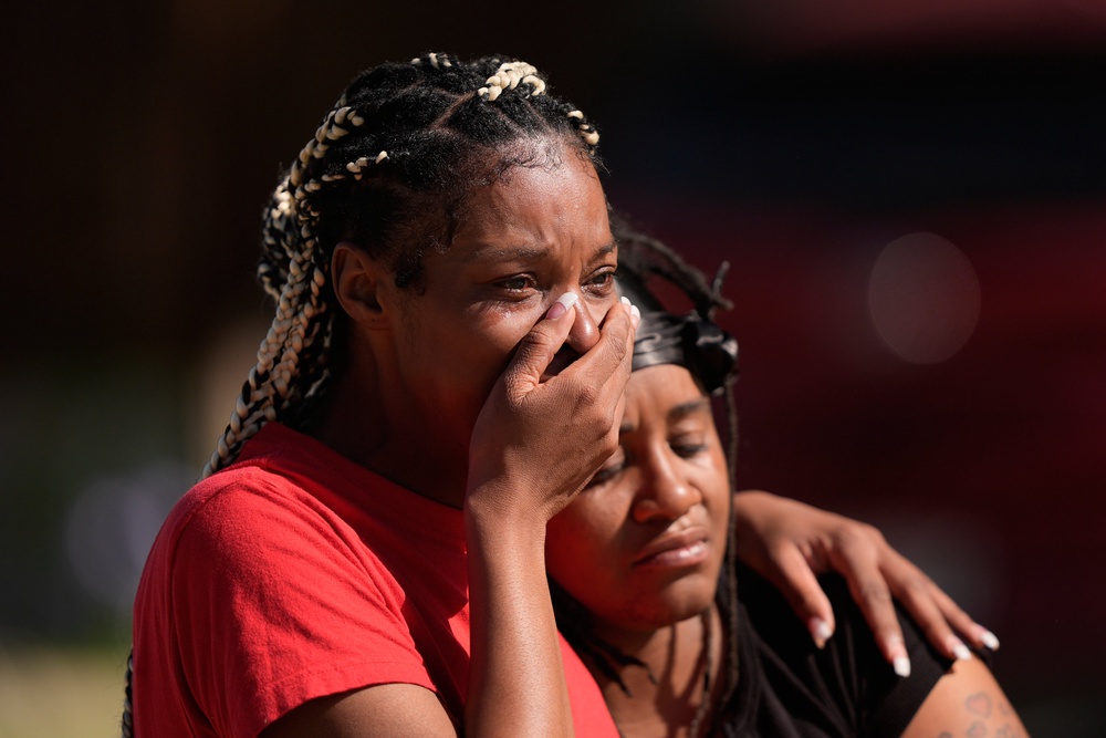 Residents gathered around the scene to grieve Sunday, with one saying: ‘Nothing like this has ever happened on this street’ (AP)