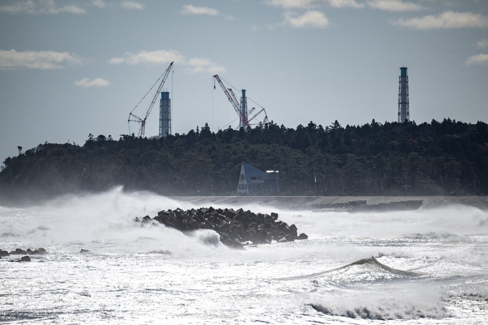 An abandoned building in front of the facilities of the Tokyo Electric Power Company's (TEPCO) Fukushima Daiichi Nuclear Power Plant (back), as seen from Ukedo fishing port in Namie, Fukushima prefecture (AFP/Getty)
