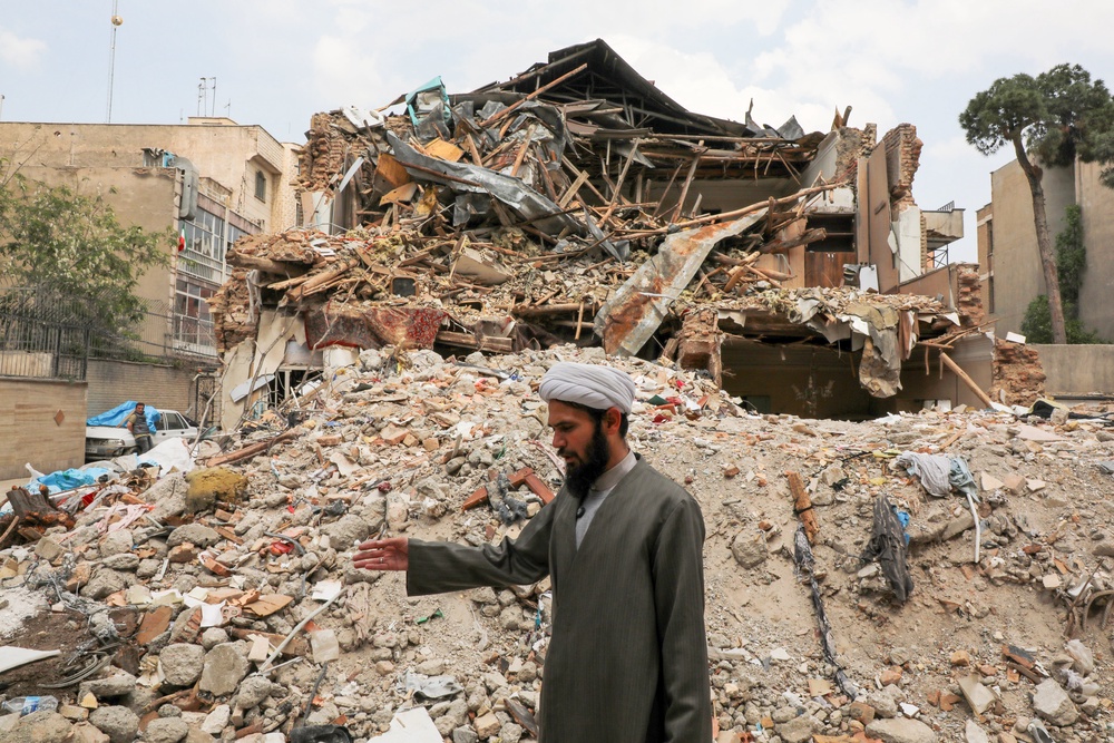 A cleric stands among the ruins of a Jewish synagogue that was previously damaged during US-Israeli strikes (Getty)