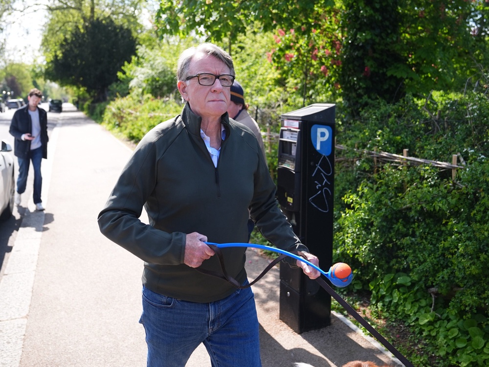 Lord Peter Mandelson taking his dog for a walk near his home in London today (PA)