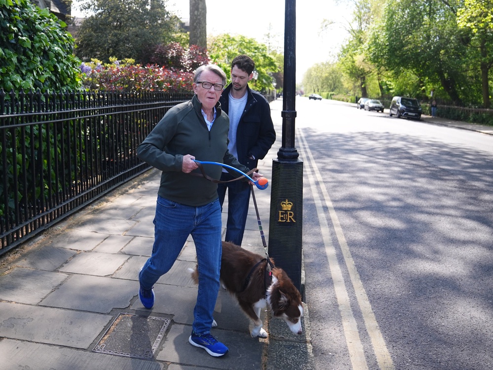 Lord Peter Mandelson (left) taking his dog for a walk near his home in London (PA)