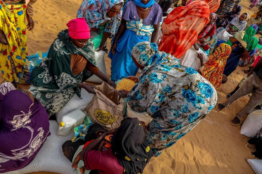 Refugees share the distributed food aid, which includes sorghum, legumes, oil, and salt. in Ouaddai, Chad (WFP/Arete/Salamon Djek)