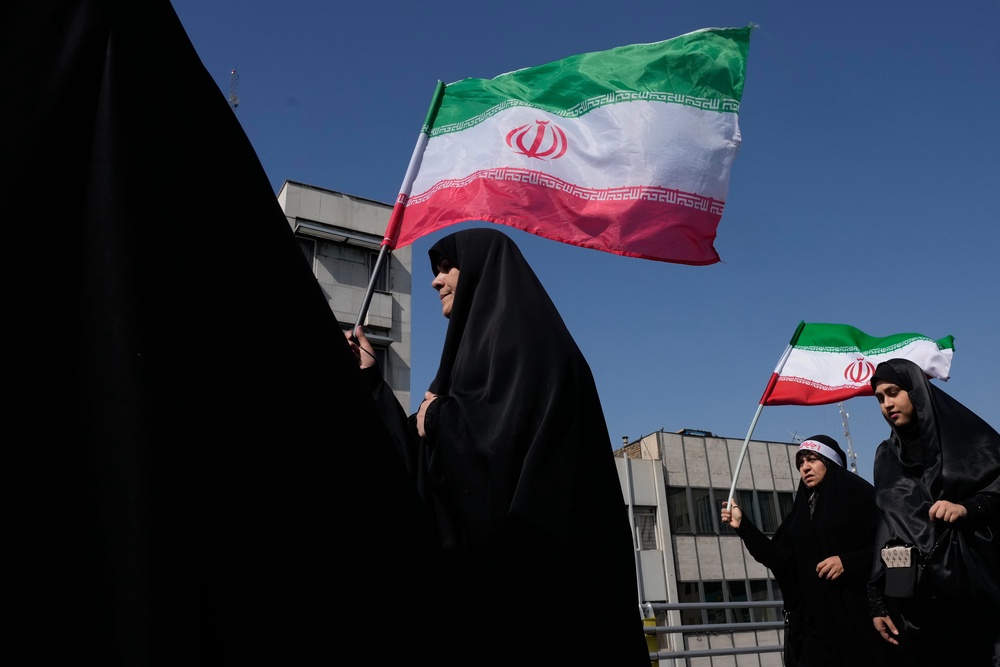 Women carry Iranian flags during a state-organised rally in support of the supreme leader marking National Girl’s Day in Tehran, Iran (Vahid Salemi/AP) (AP)