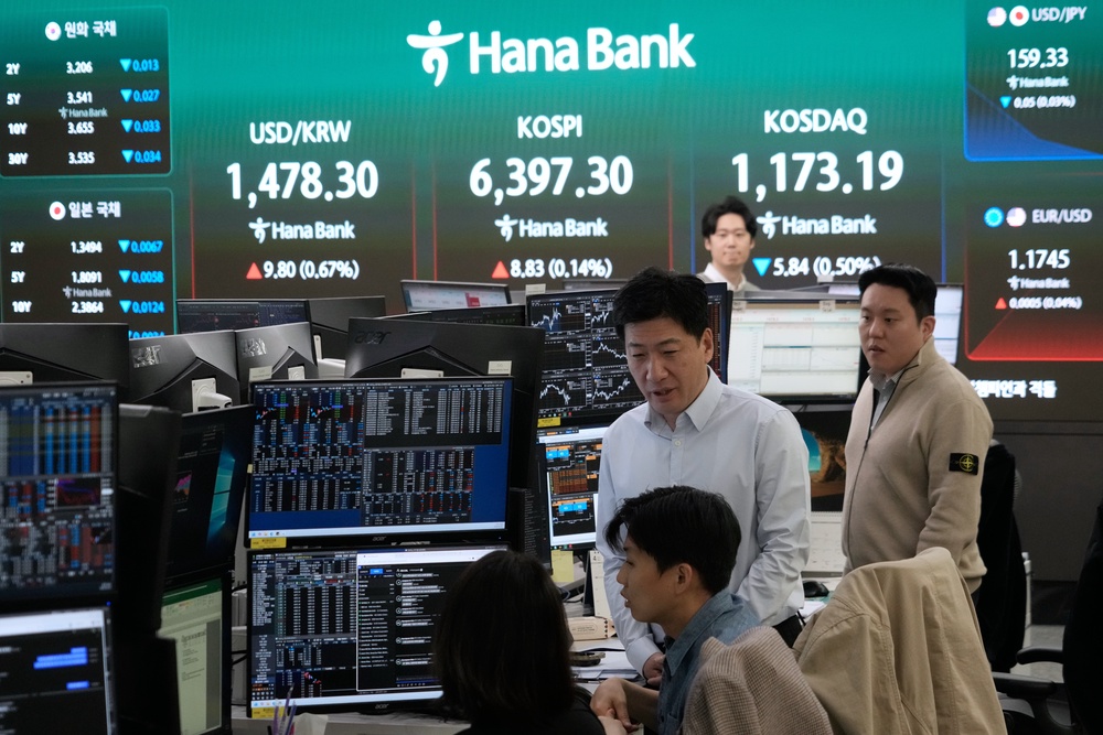 Currency traders work near a screen showing the Korea Composite Stock Price Index (AP)