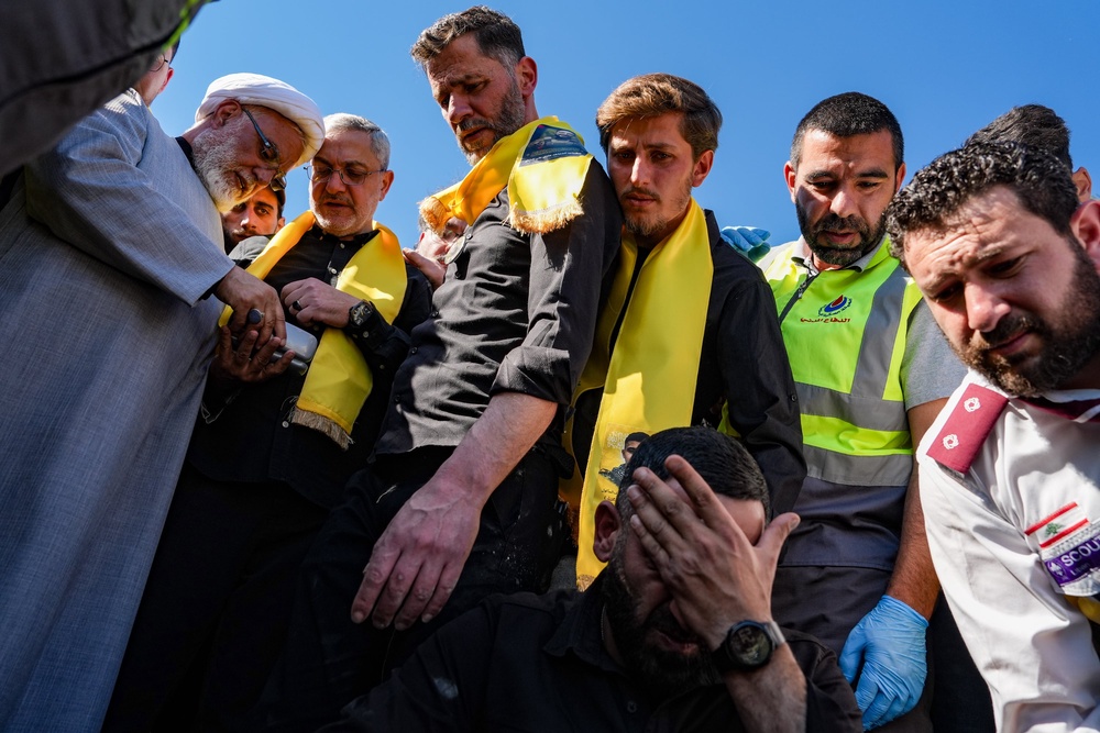Men look upon the casket of a Hezbollah fighter that was killed by an Israeli strike last week while it is lowered into a grave during a funeral on 22 April 2026 in Tyre, Lebanon (Getty)