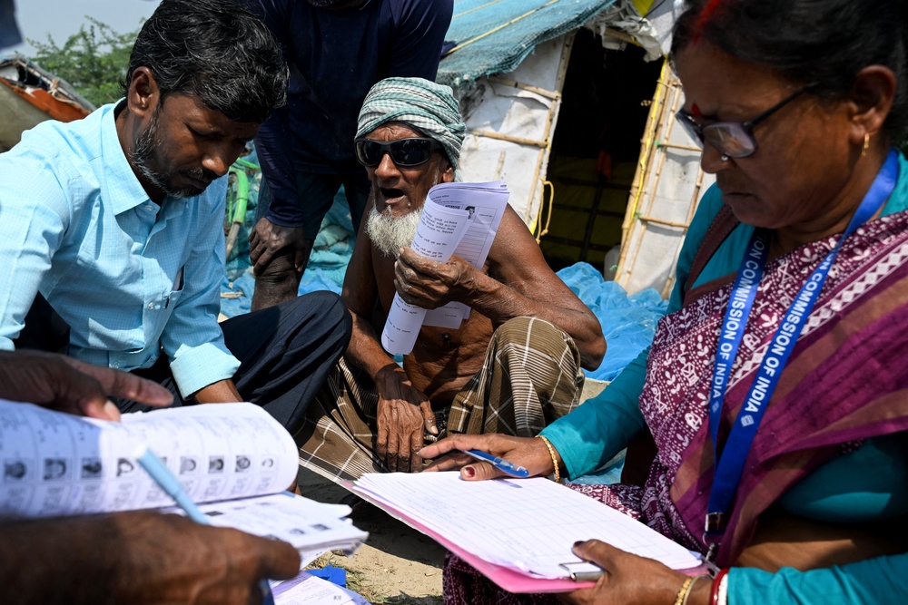 Officials distribute enumeration forms as a part of the election commission’s Special Intensive Revision (SIR), at a fishing village on Mousuni Island (AFP/Getty)