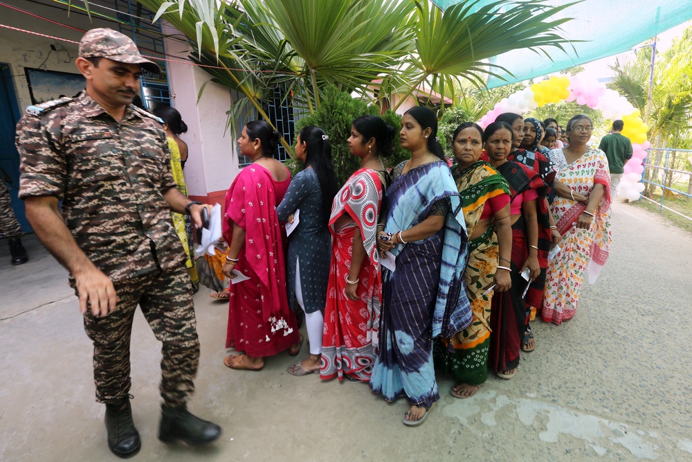 Voters queue at a polling booth for the first phase of voting in West Bengal state elections in Nandigram, a town to the south of Kolkata (AP)